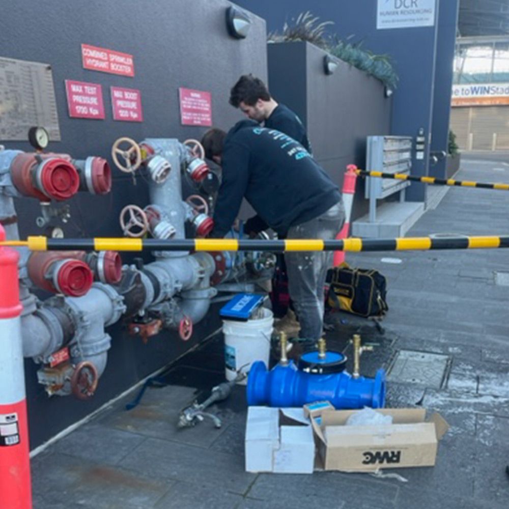 CityWide plumbers working on a fire hydrant booster at a commercial building